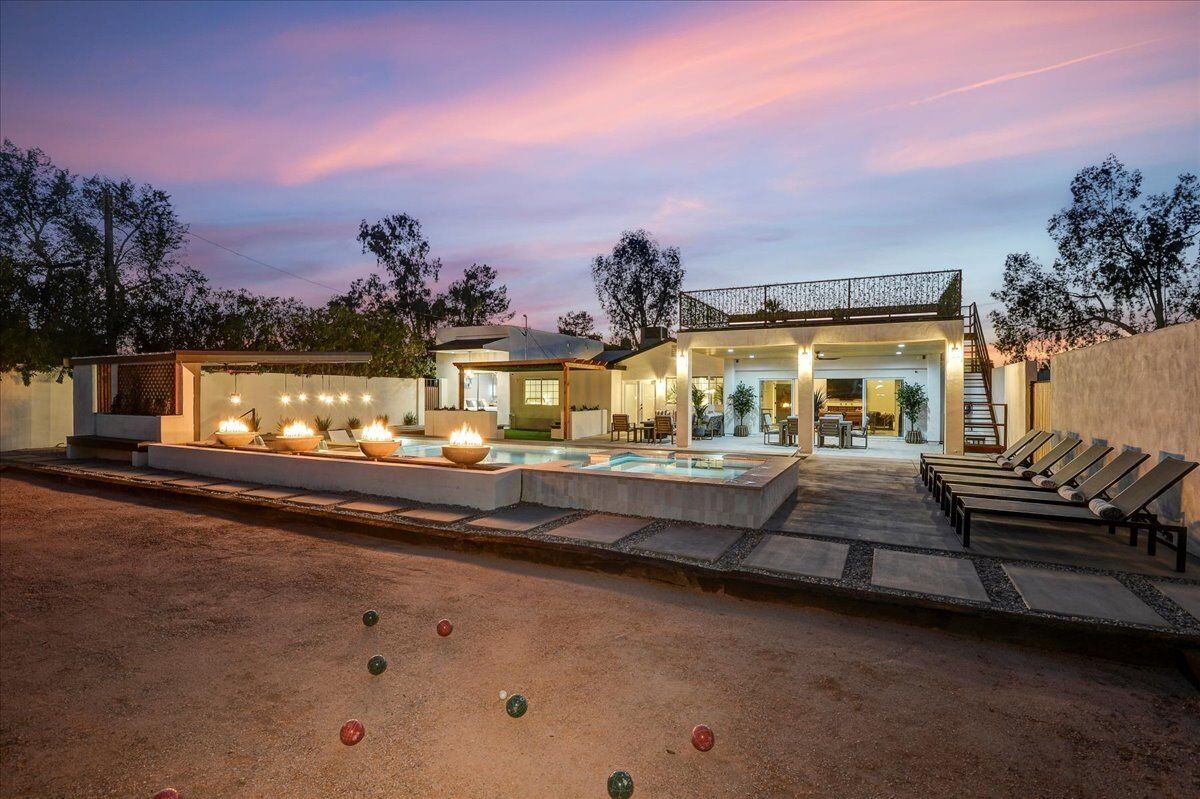 Wide twilight view of the full backyard including bocce court