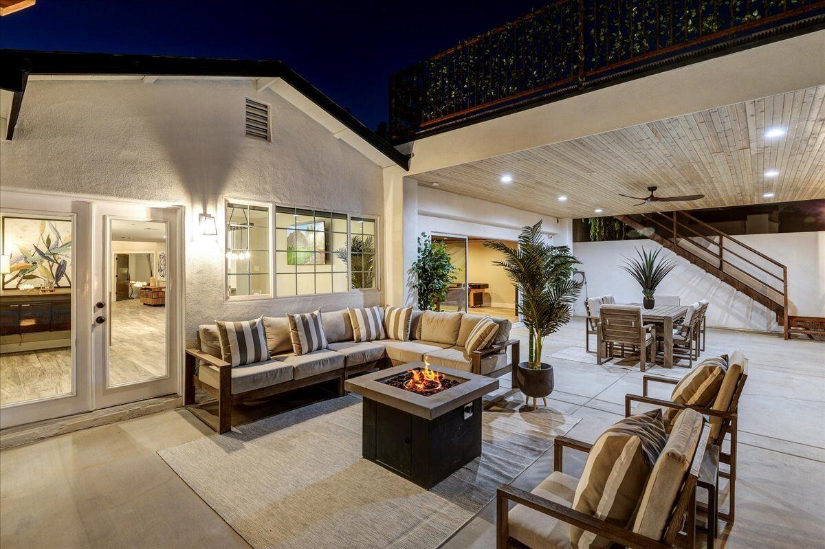 Covered patio lounge with fire pit table at night