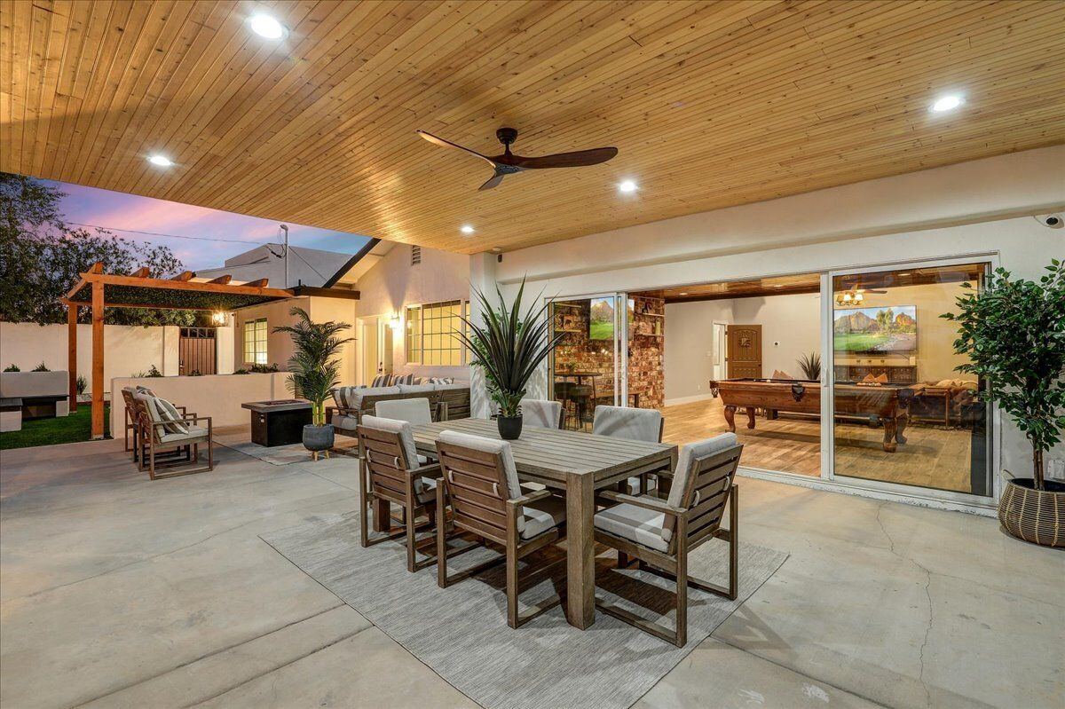 Covered patio dining area with games room visible through sliding doors